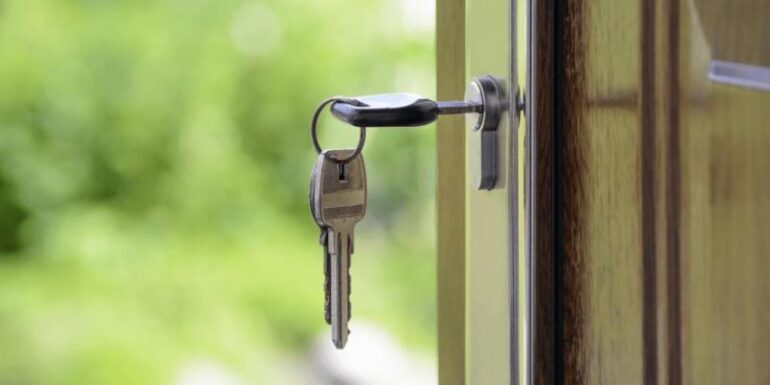 A key hanging out of a door.