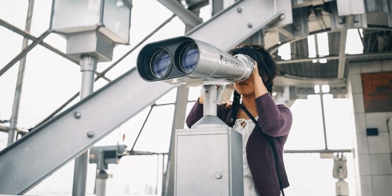 Woman looking through binoculars.