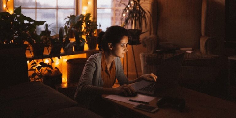 A woman working at home by candlelight.